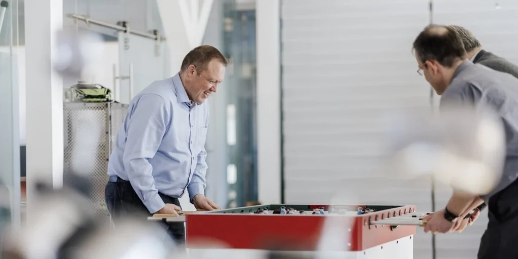 Kollegen an einem Tischkicker im Büro